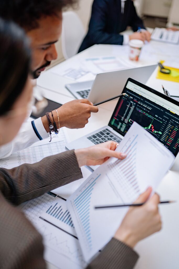 pexels-photo-7693254-7693254 Team collaborating with laptops and documents in an office setting, analyzing data.